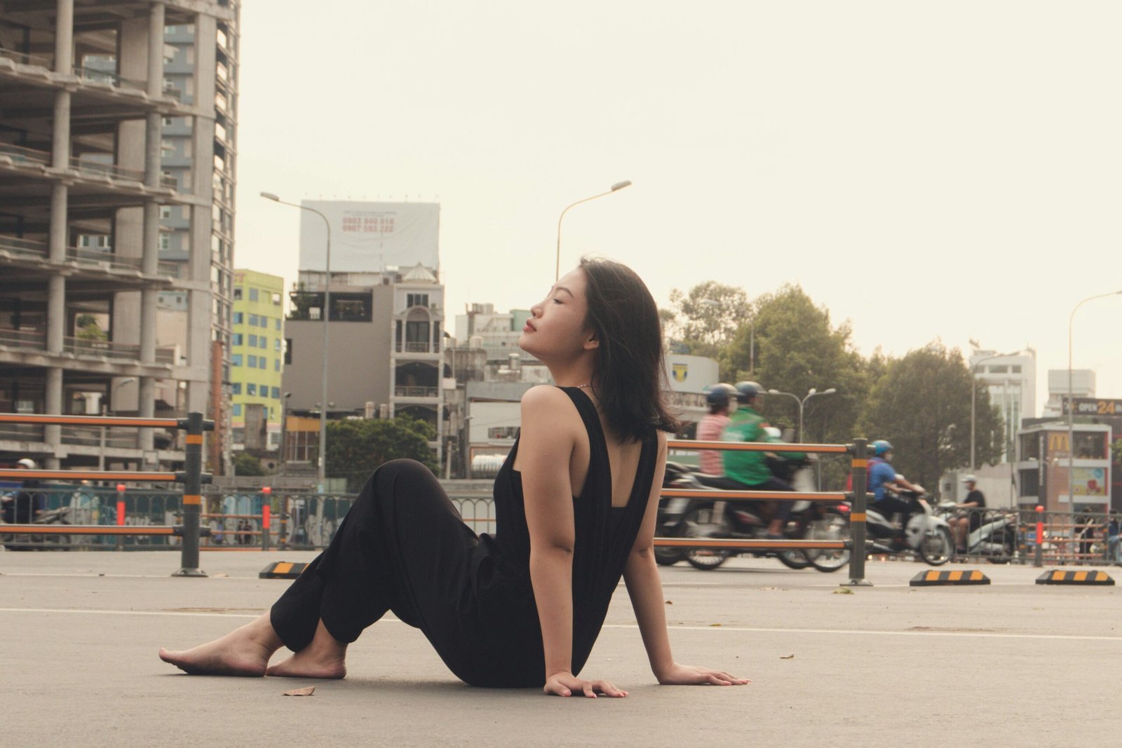 a woman sitting on the ground in the middle of a city